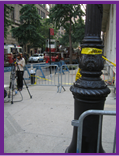 Street scene with lightpole with crime scene tape tied to it.
