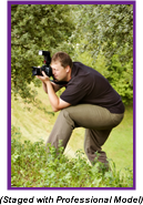 Man with camera crouching in the bushes (Staged with Professional Model).
