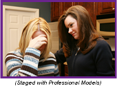 Counselor comforting a crying woman (Staged with professional models.)